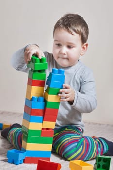 Playing little boy with colored cubes