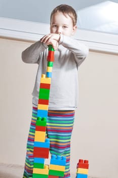Playing little boy with colored cubes