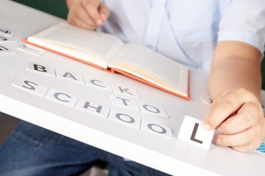 boy sitting at school desk with the inscription of the numbers back to school