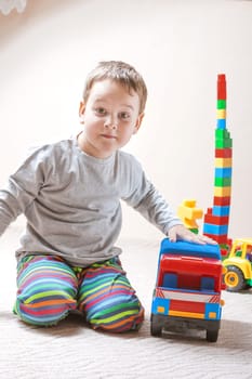 Playing little boy with colored cubes