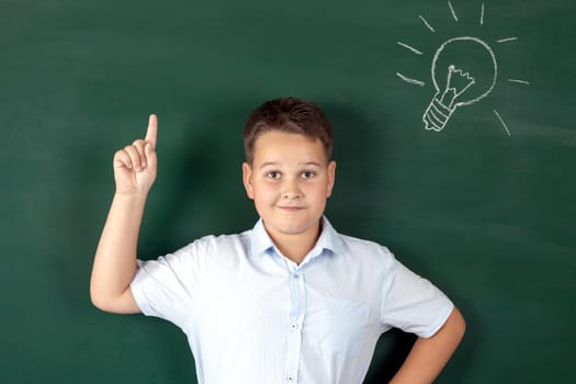 boy in a shirt with school boards with bulb and idea