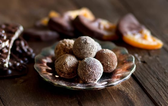 Chocolate, truffles and orange slices in dark chocolate on a wooden table