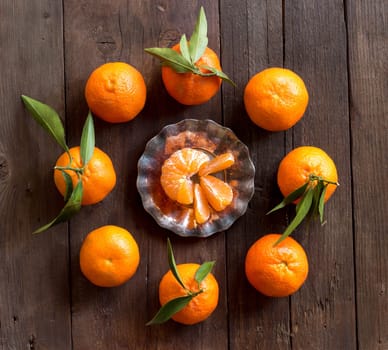 Fresh Tangerines with green leaves on a wooden background