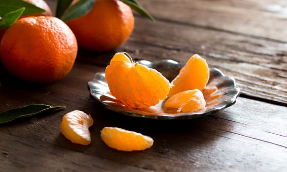 Fresh Tangerines with green leaves on a wooden background