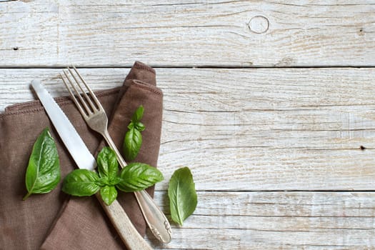 Vintage fork and knife on a napkin on a old wooden table
