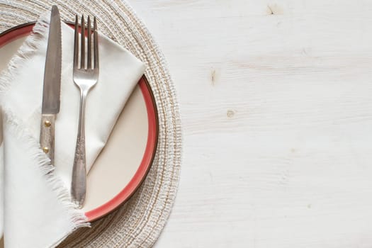 Vintage fork and knife on a plate on a old wooden table