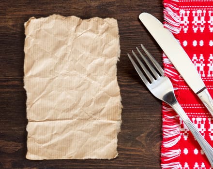 Fork and knife on kitchen towel and old wooden table