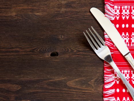 Fork and knife on kitchen towel and old wooden table