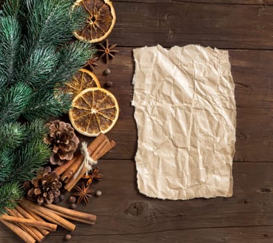 Christmas composition with spices and paper on wood