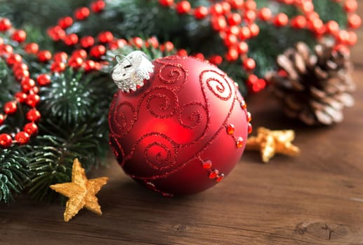 Christmas composition with bauble and branches on wood