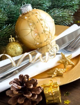 Festive table setting with golden bauble and plate