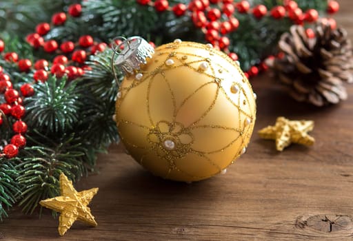 Christmas composition with bauble and branches on wood