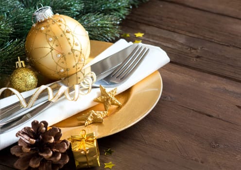 Festive table setting with golden bauble and plate