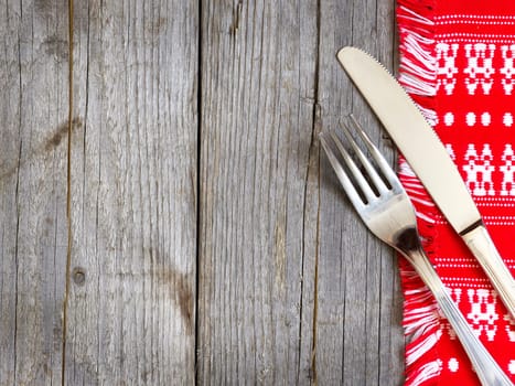 Fork and knife on kitchen towel and old wooden table