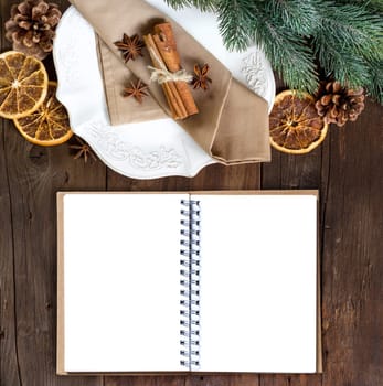 Festive table setting with spices and notebook on wooden table