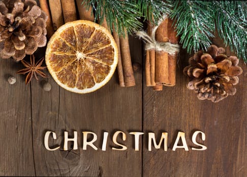 The word of christmas with border of spices, pine cones and fir