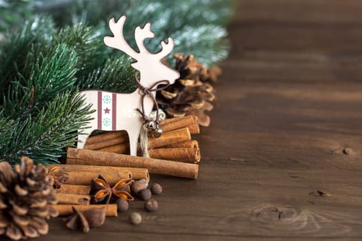 Christmas background with tree branch, spices, pine cones and deer