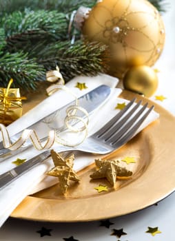 Festive table setting with golden bauble and plate