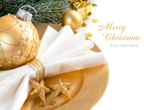 Festive table setting with golden bauble and plate