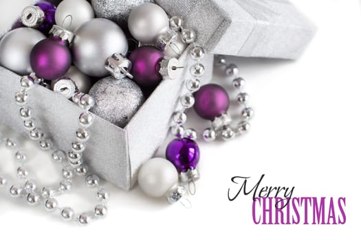 Silver and purple Christmas ornaments border on white background