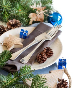 Blue and brown Christmas table setting with rustic decorations on wood