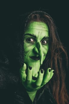 Green witch acting like she is holding something. Shallow depth of field.