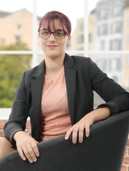 portrait of a young business woman smiling, in an office