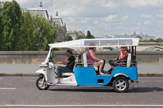 tourists on a city tour in a tuk tuk in paris