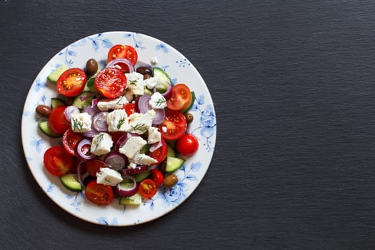 Greek salad with tomatoes, feta cheese, cucumbers, onions and olives