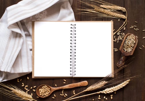 Notebook and wheat on a napkin with old wood background