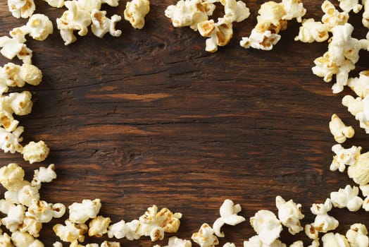 Frame of popcorn on wood background with copyspace