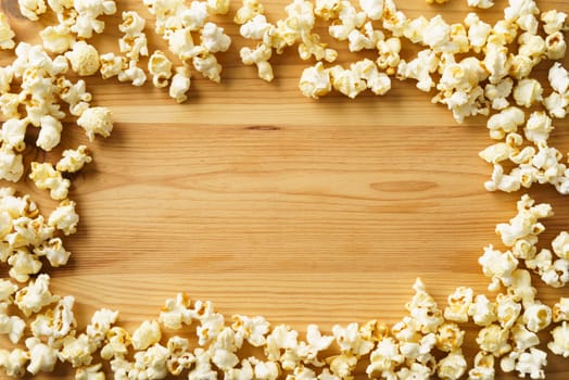 Frame of popcorn on wood background with copyspace