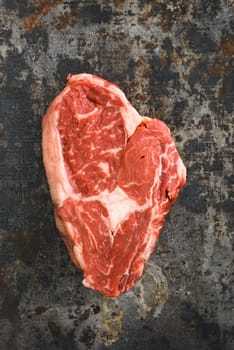 Rib eye steak on dark rustic background