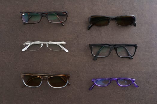 Collection of glasses and sunglasses on faux leather