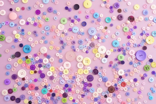Collection of buttons in pink and pastel colours on pink background
