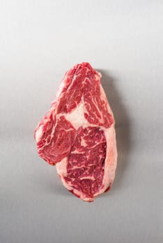 Raw rib eye steak on stainless steel