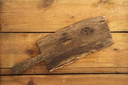 Old wooden cutting board on wooden background