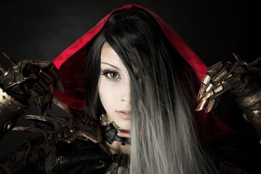 Girl in a dark Red riding hood costume with a dark background
