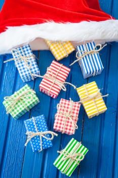 Small colorful gifts on a rustic background of blue wood