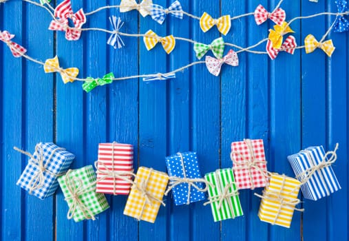 Small colorful gifts on a rustic background of blue wood