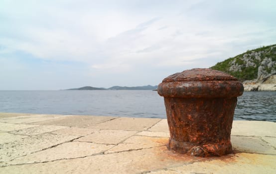 Rusty metal mooring bolard for big ship.