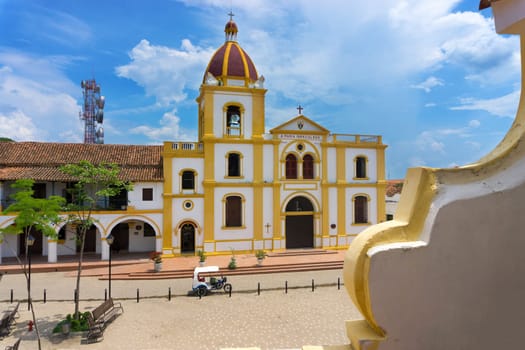 Church of the Immaculate Conception with a motor taxi parked in front in Mompox, Colombia