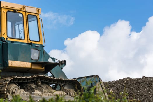 Excavator construction machine on a construction site in the background a blue sky..