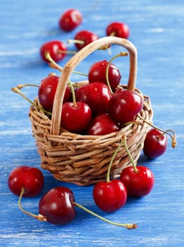 Red cherries in a basket on a blue background
