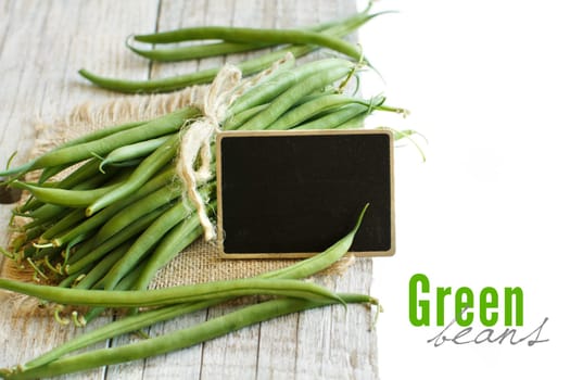 Fresh green french beans on a wooden background