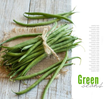 Fresh green french beans on a wooden background