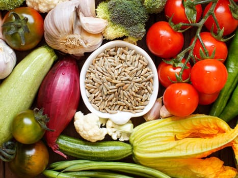 Raw Rye Grain in a bowl and vegetables top view