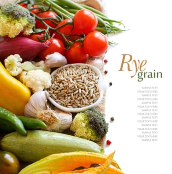 Raw Rye Grain in a bowl and vegetables isolated on white