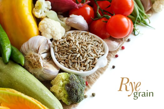 Raw Rye Grain in a bowl and vegetables isolated on white