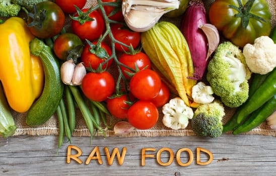 Fresh vegetables and wooden letters on an old wooden table